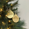 Gold Christmas ornaments on a decorated tree with lights.
